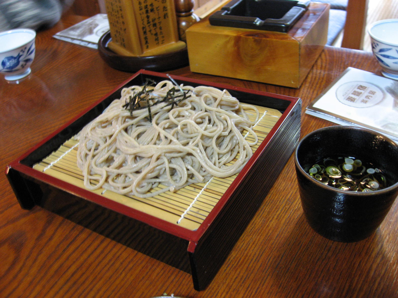 Illustrative Japanese zaru soba on a bamboo tray with a separate dipping cup